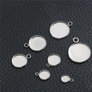 Set of seven circular stainless steel bezel trays for jewelry making on black leather
