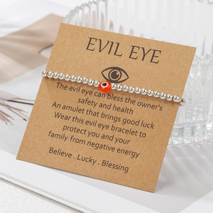 Detail of silver beaded evil eye bracelet on brown gift card with emotional message