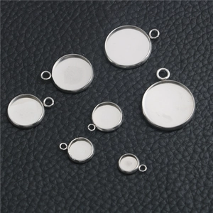 Flat lay of seven circular stainless steel pendant trays in various sizes on black leather