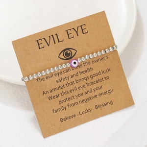 Detail of silver CCB beaded Evil Eye bracelet on kraft card with purple eye charm