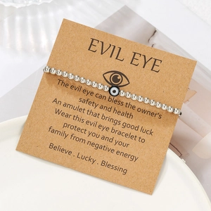 Detail of silver beaded Evil Eye friendship bracelet on a kraft gift card display
