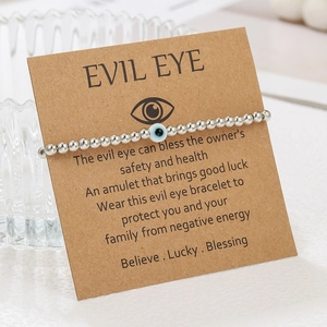 Close-up of silver CCB beaded Evil Eye bracelet on kraft paper gift display card