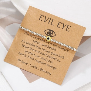 Detail of silver beaded evil eye bracelet on kraft paper gift card packaging