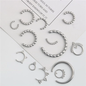 Set of 13 silver stainless steel ear cuffs and nose rings in various minimalist designs