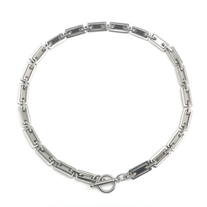 Collana a maglie geometriche in acciaio inossidabile con chiusura a T su sfondo bianco