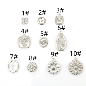 Detailed macro view of 10 vintage silver floral and clover charms for DIY jewelry