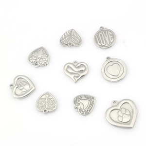 Macro shot of stainless steel heart and tree of life charms for DIY jewelry making