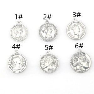 Detail of six stainless steel coin pendants with queen relief for DIY jewelry making