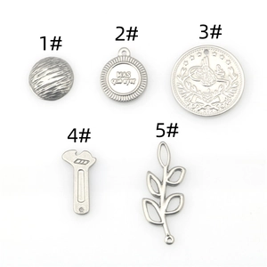 Detailed set of silver stainless steel charms featuring wrench, leaf, and engraved coin designs