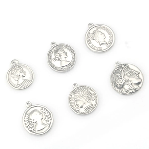 Set of vintage stainless steel coin pendants with queen head reliefs on white background