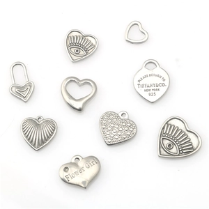 Detailed close-up of heart-shaped stainless steel pendants with various textures and engravings