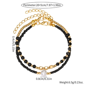Tobillera bohemia de doble capa con cuentas negras y doradas y detalle de perla elegante