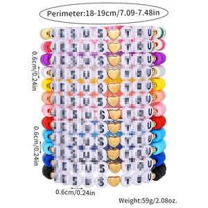 Détail de bracelets en perles heishi colorées avec cœurs dorés et breloques de lettres