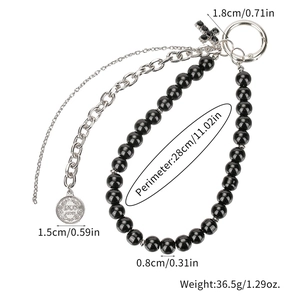 Detail of vintage beaded chain with cross pendant and Dos Pesos coin charm