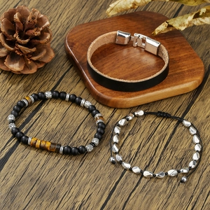 Set di bracciali in pelle da uomo con perline occhio di tigre e pietre opache su legno antico