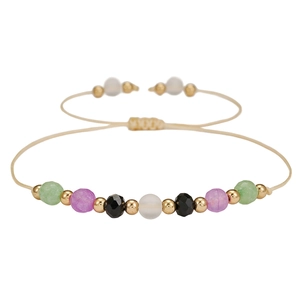 Detalle de la pulsera hecha a mano con cuentas coloridas y espaciadores dorados