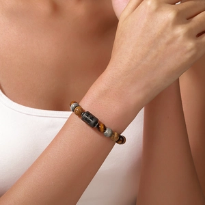 Primer plano de cuentas de ojo de tigre y cuenta de constelación grabada en pulsera de piedra