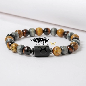 Pulsera signo Tauro con cuentas de ojo de tigre y símbolo grabado sobre fondo blanco