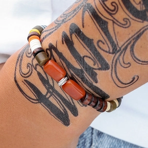 Detail van een etnische kralenarmband met bruine agaat en zilveren metalen tussenstukjes