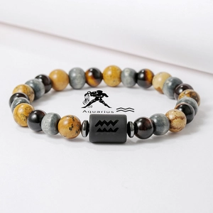 Detalle de pulsera Acuario con cuentas de ojo de tigre y símbolo zodiacal grabado
