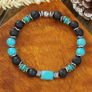 Kralenarmband van turquoise en kokosnootschaal met zwarte lavasteen op houten bord