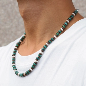 Detalle de collar bohemio para hombre con cuentas de coco y turquesa sobre modelo
