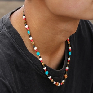 Gros plan du collier bohème en perles de coco colorées avec des séparateurs en bronze au cou