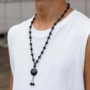 Detailaufnahme der schwarzen Onyx-Halskette mit rundem Anhänger und Quaste