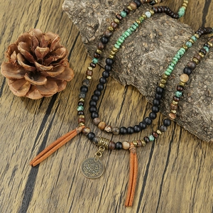 Bohemian tribal necklace with coins, turquoise beads, and leather tassels on rustic wood
