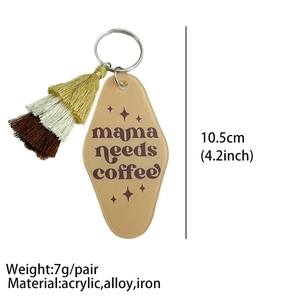 Macro view of hotel-style acrylic keychain with mama needs coffee text and tassel