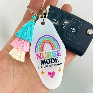 Acrylic nurse keychain with colorful tassels and 'Nurse Mode' lettering held in hand