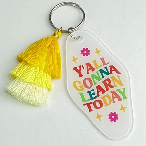 Detail of teacher acrylic keychain with pink floral pattern and colorful layered tassels