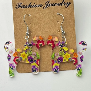 Gros plan détaillé de boucles d'oreilles chien à motifs floraux sur carte