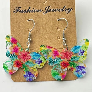 Boucles d'oreilles papillon colorées en acrylique sur carte brune avec crochets argentés