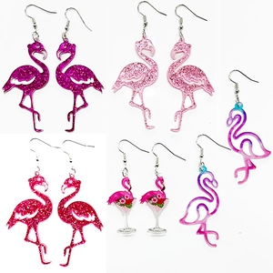 Macro shot of glittery pink flamingo earrings with acrylic cocktail glass pendants