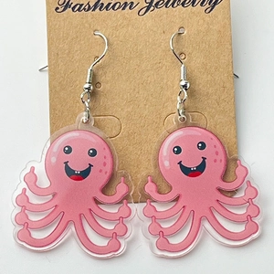 Boucles d'oreilles poulpe rose en acrylique avec geste du doigt sur un support
