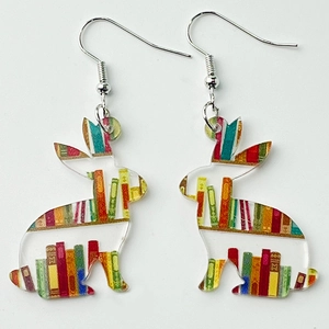 Detail of acrylic rabbit earrings featuring a colorful vintage bookshelf and library print
