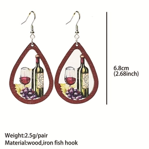 Detail view of teardrop wood earrings featuring red wine and grape printed patterns