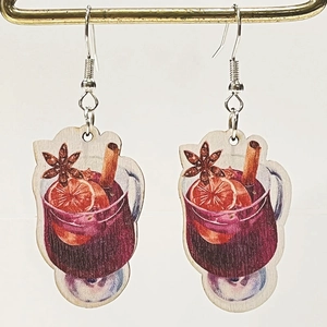 Detail of wooden mulled wine glass earrings with orange and cinnamon illustrations