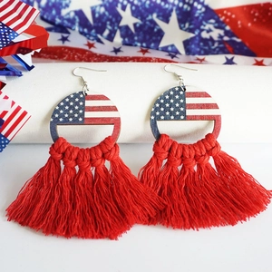 Détail macro de boucles d'oreilles drapeau USA avec de longs pompons rouges bohèmes