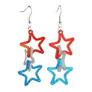 Close-up of glitter patriotic star drop earrings with rotating red silver and blue layers