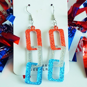 Macro view of interlocking red white and blue glitter acrylic chain link earrings