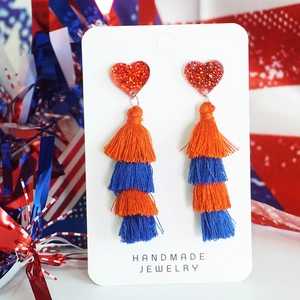 Detail of red sequin heart earrings with bohemian blue and orange layered tassels