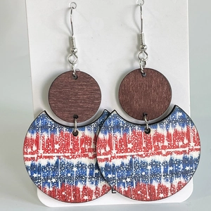 Détail de boucles d'oreilles géométriques en bois avec motifs étoiles et rayures tricolores