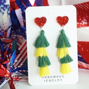 Detail of handmade heart sequin earrings with colorful yellow and green tiered fringe tassels