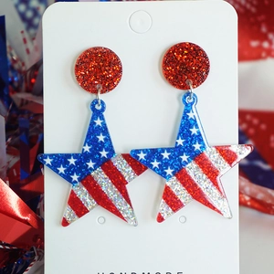 Macro shot of glittering red, blue, and silver patriotic star earrings for festive parties