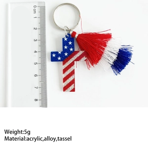 Macro shot of 7cm USA flag cross keychain with acrylic glitter and colorful tassels