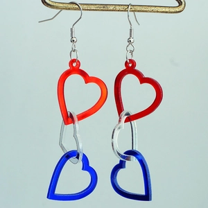 Detail of red, white and blue interlocking acrylic hearts on long drop earrings