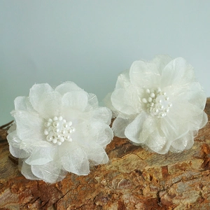 Detailaufnahme handgefertigter weißer Organza-Blumenohrringe mit eleganten Perlen