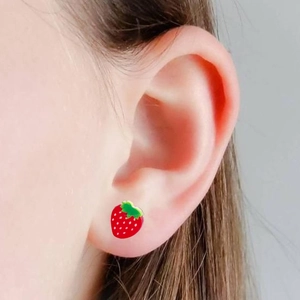 Cute strawberry stud earrings with green leaf details shown on female model ear